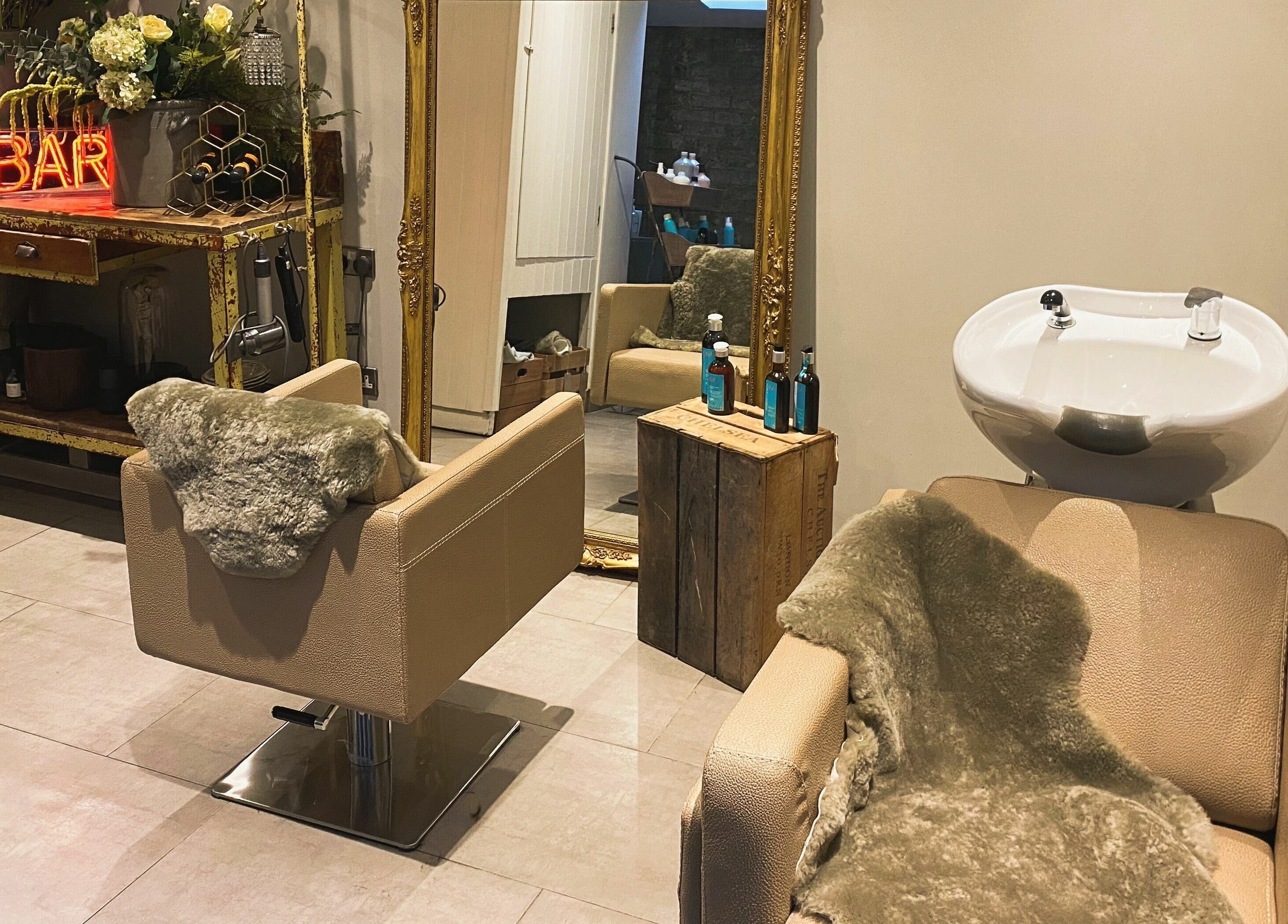 Elegant salon interior at Aimee-Blu, London, England, GB with plush styling chairs and rustic decor.