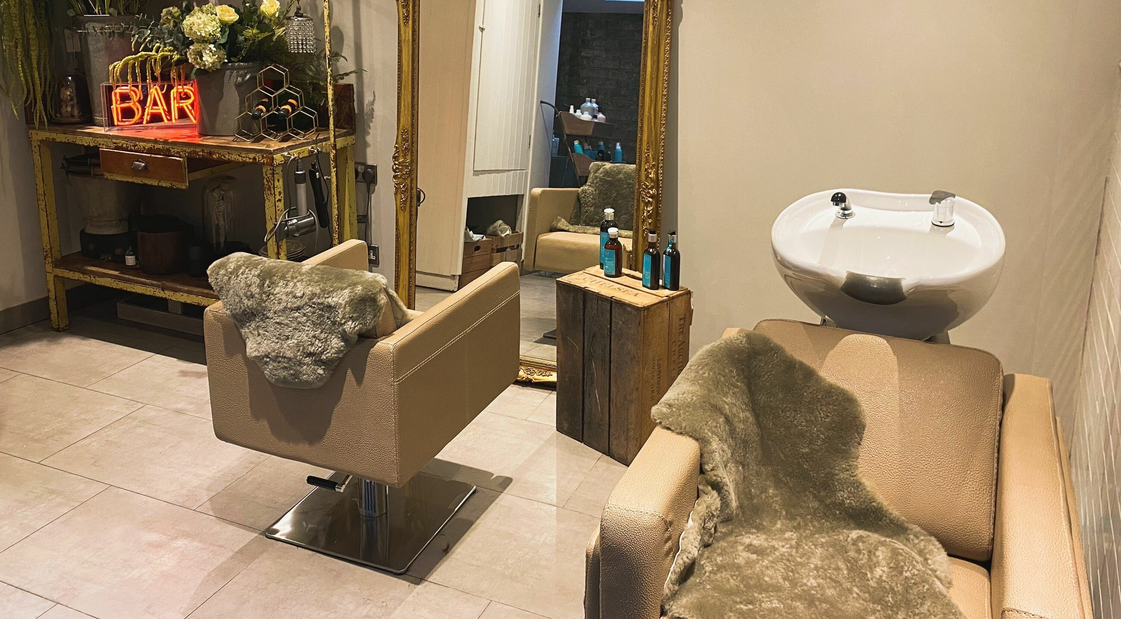 Elegant salon interior at Aimee-Blu, London, England, GB with plush styling chairs and rustic decor.