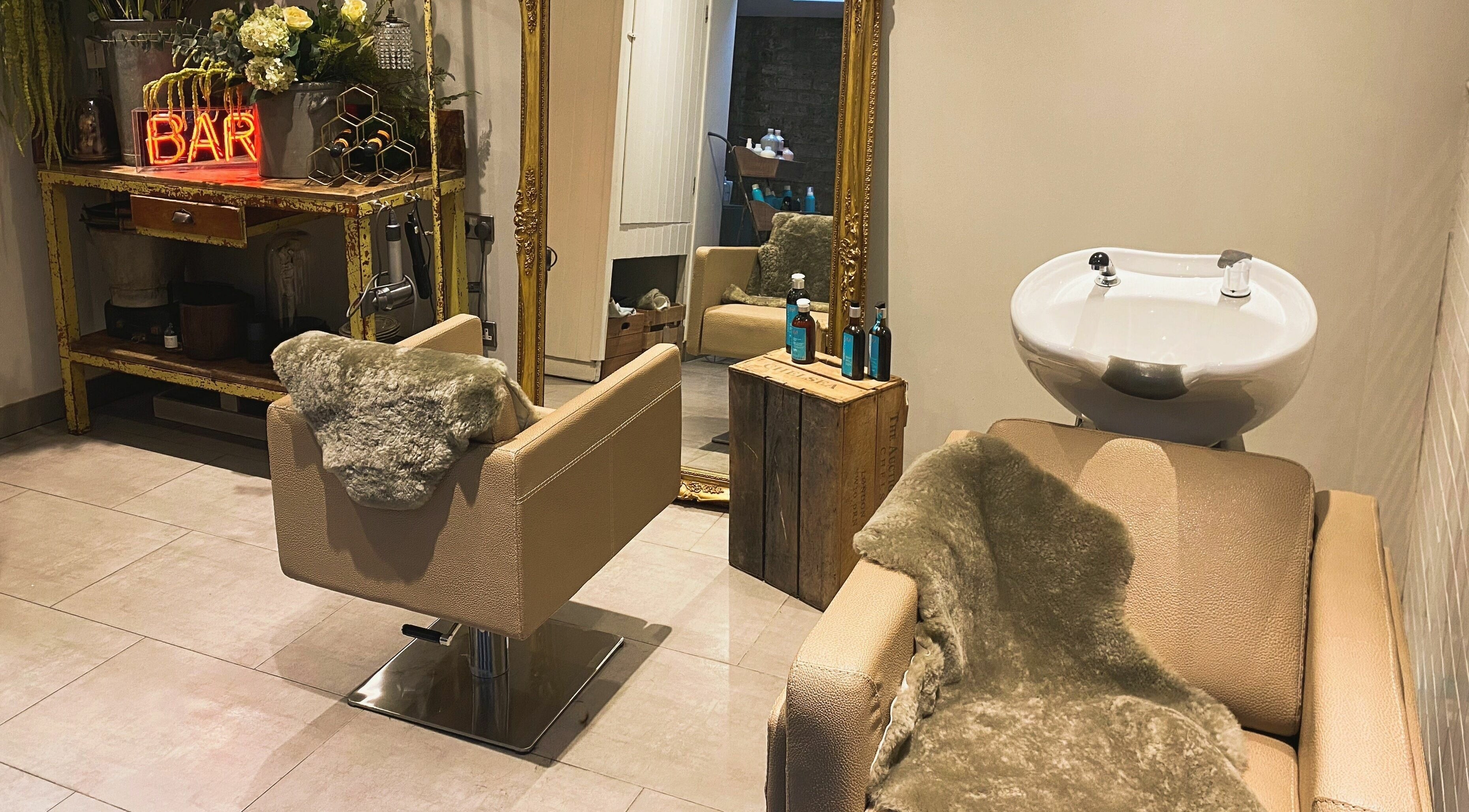 Elegant salon interior at Aimee-Blu, London, England, GB with plush styling chairs and rustic decor.