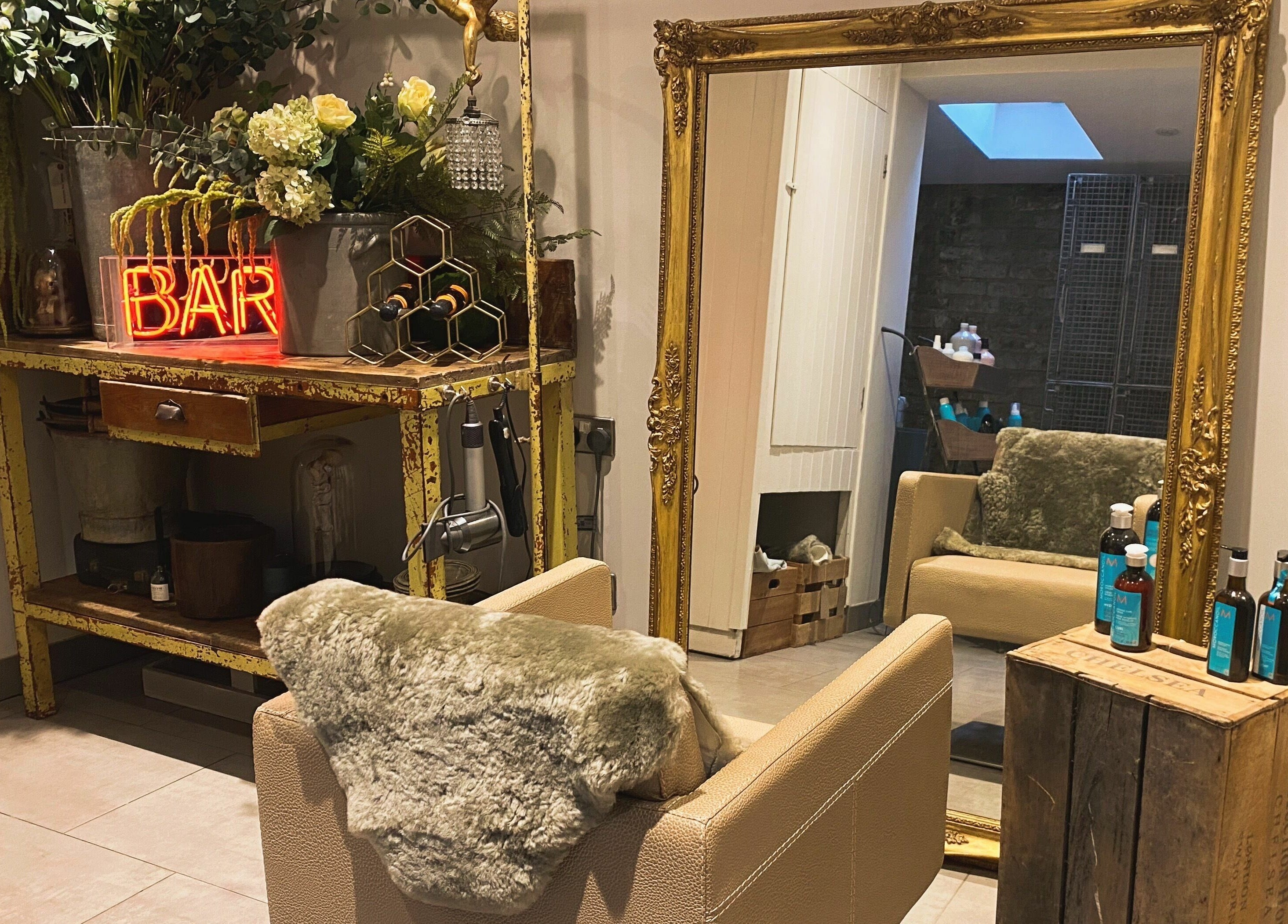 Elegant vintage decor at Aimee-Blu salon in London, England, GB, featuring ornate mirror and plush chair.