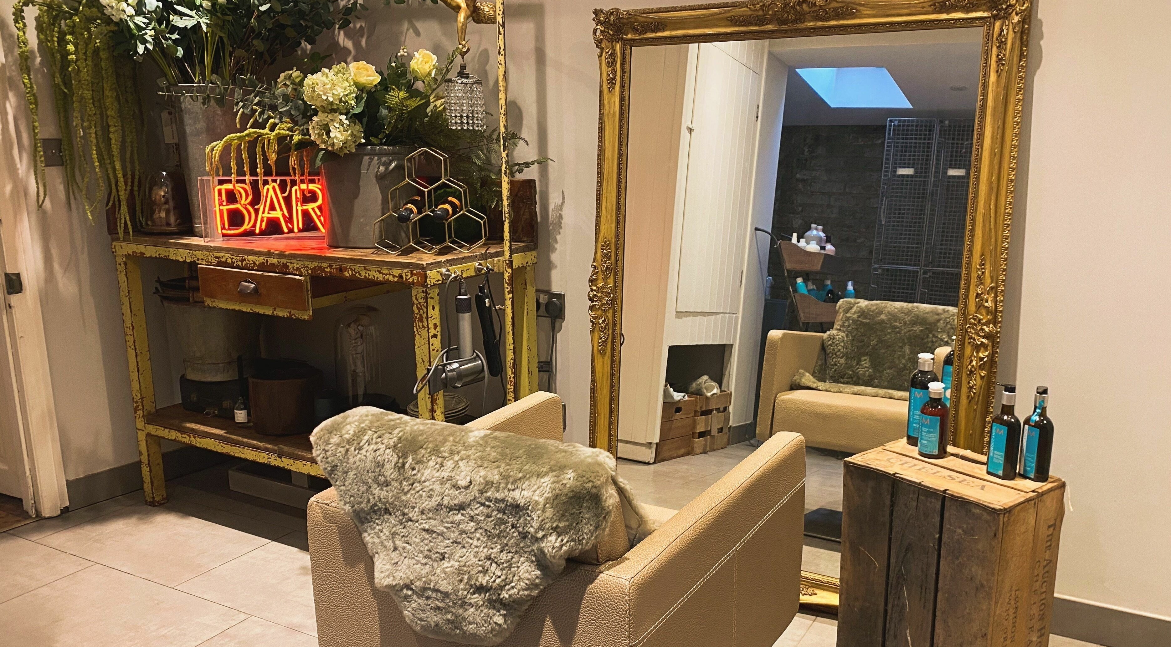 Elegant vintage decor at Aimee-Blu salon in London, England, GB, featuring ornate mirror and plush chair.