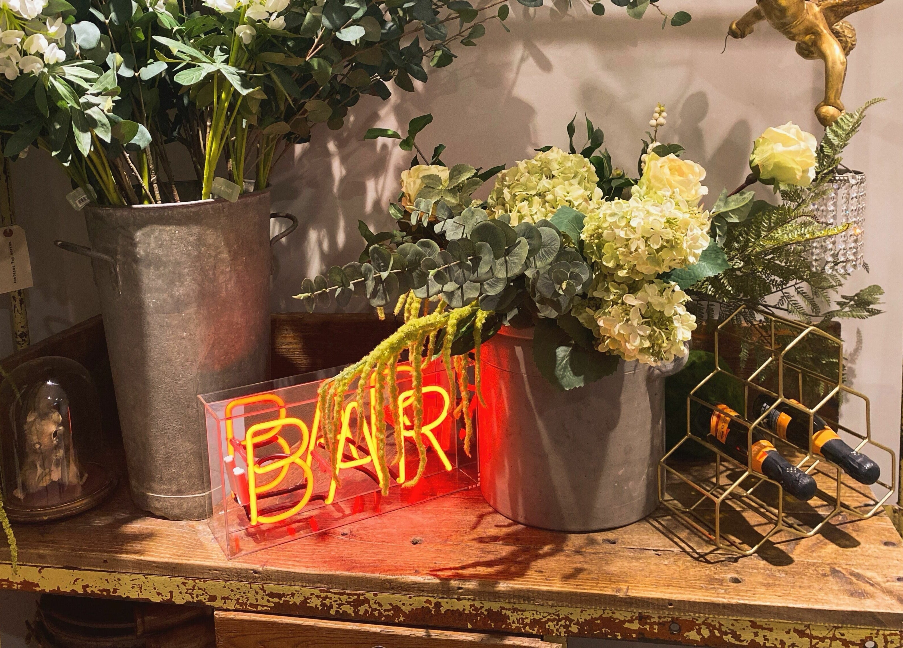 Elegant floral arrangement at Aimee-Blu, London, England, GB, featuring a rustic metal planter and lush greenery.