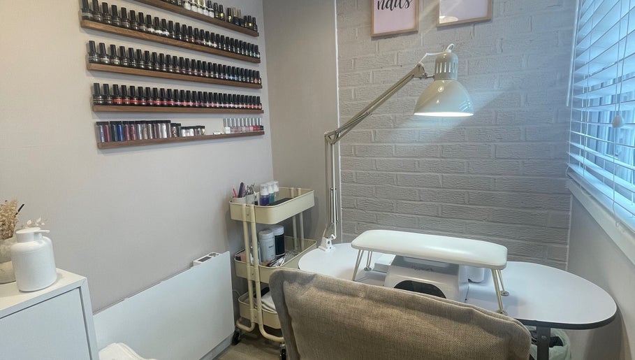 Nail studio at Nails From Natalie, Honiton, England, GB, with wall polish display and modern table.