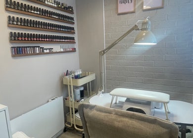 Nail studio at Nails From Natalie, Honiton, England, GB, with wall polish display and modern table.