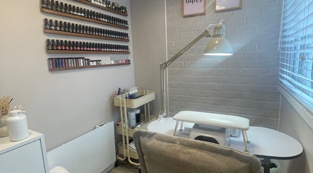 Nail studio at Nails From Natalie, Honiton, England, GB, with wall polish display and modern table.