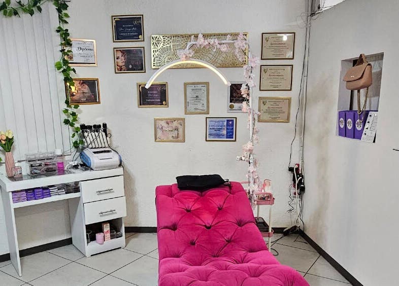 Sala de tratamiento en Fabulash By Paloma, Juárez, Chihuahua, MX, con sofá rosa y certificados en la pared.