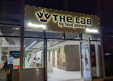 Night view of The Lab Gents Salon & Spa at Meadows Town Center, Dubai, AE, showcasing the welcoming entrance.