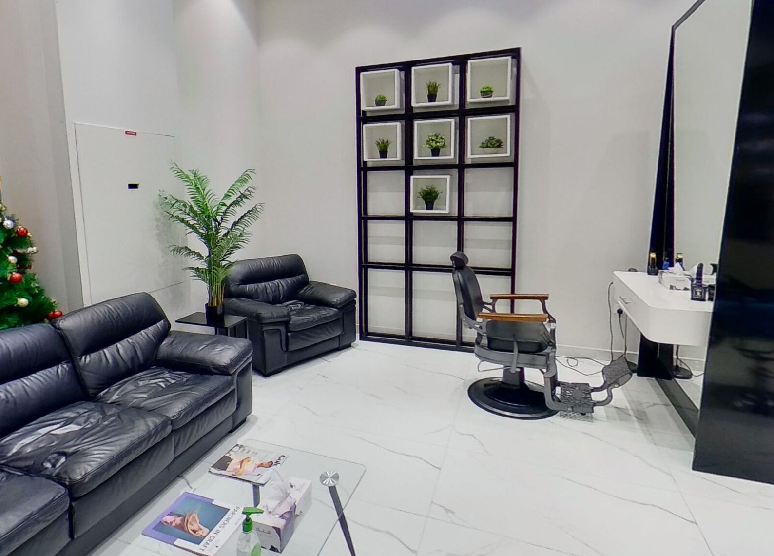 Elegant interior of The Lab Gent's Salon & Spa - Arabian Ranches 2, Dubai, AE with black leather sofas and decor.