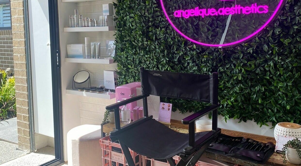 Angelique Aesthetics lounge featuring a neon sign, makeup chair, and product shelf in Melbourne, Victoria, AU.