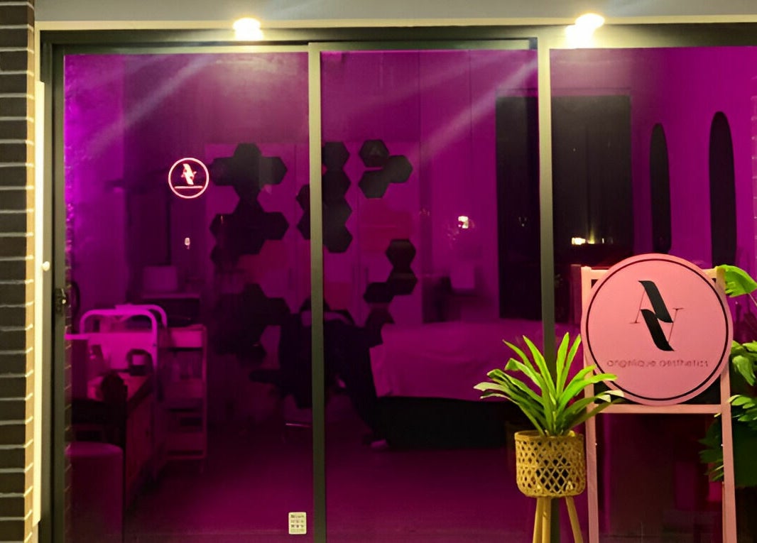 Entrance of Angelique Aesthetics in Melbourne, Victoria, AU, with vibrant purple glow and elegant decor.