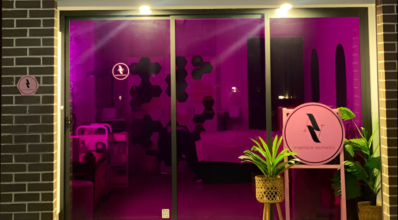 Entrance of Angelique Aesthetics in Melbourne, Victoria, AU, with vibrant purple glow and elegant decor.