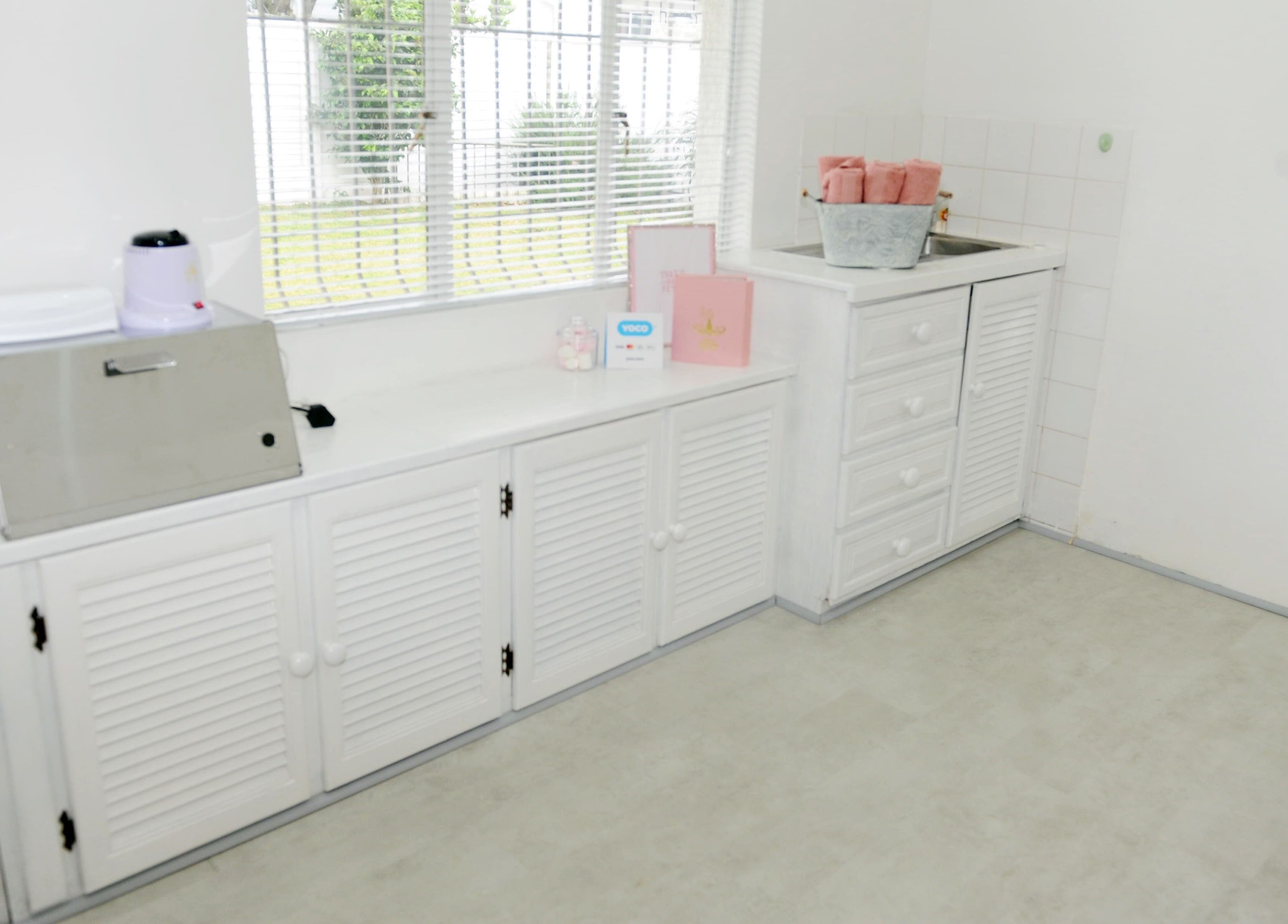 Bright and clean interior of Clawed by the Miracle, Gqeberha, Eastern Cape, ZA with organized white cabinetry.