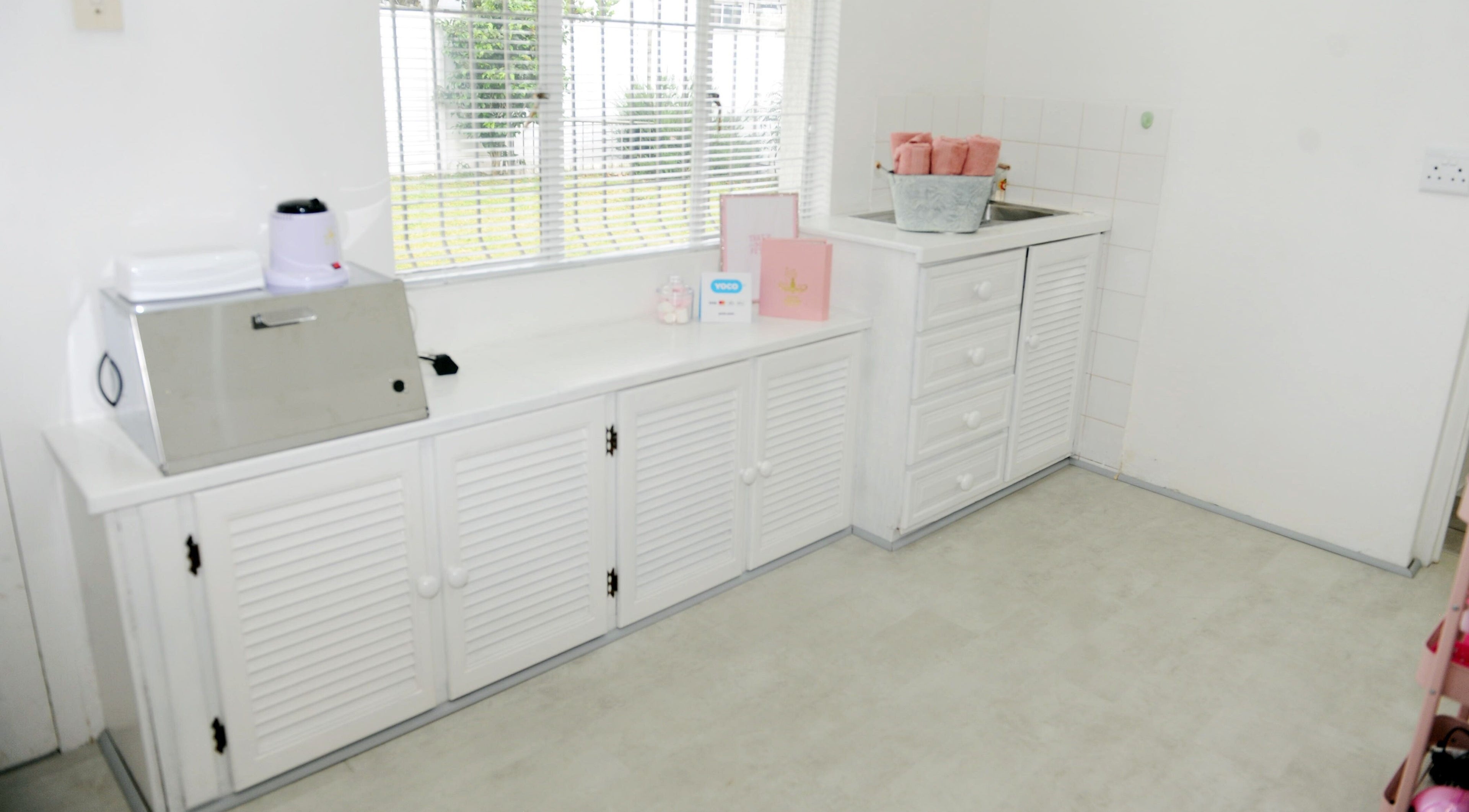 Bright and clean interior of Clawed by the Miracle, Gqeberha, Eastern Cape, ZA with organized white cabinetry.