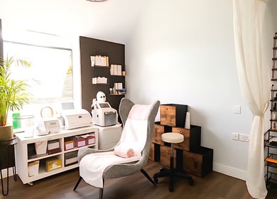 Cozy treatment room at DERMEDICA Beauty Studio, Hertford, GB with plush chair and beauty equipment.