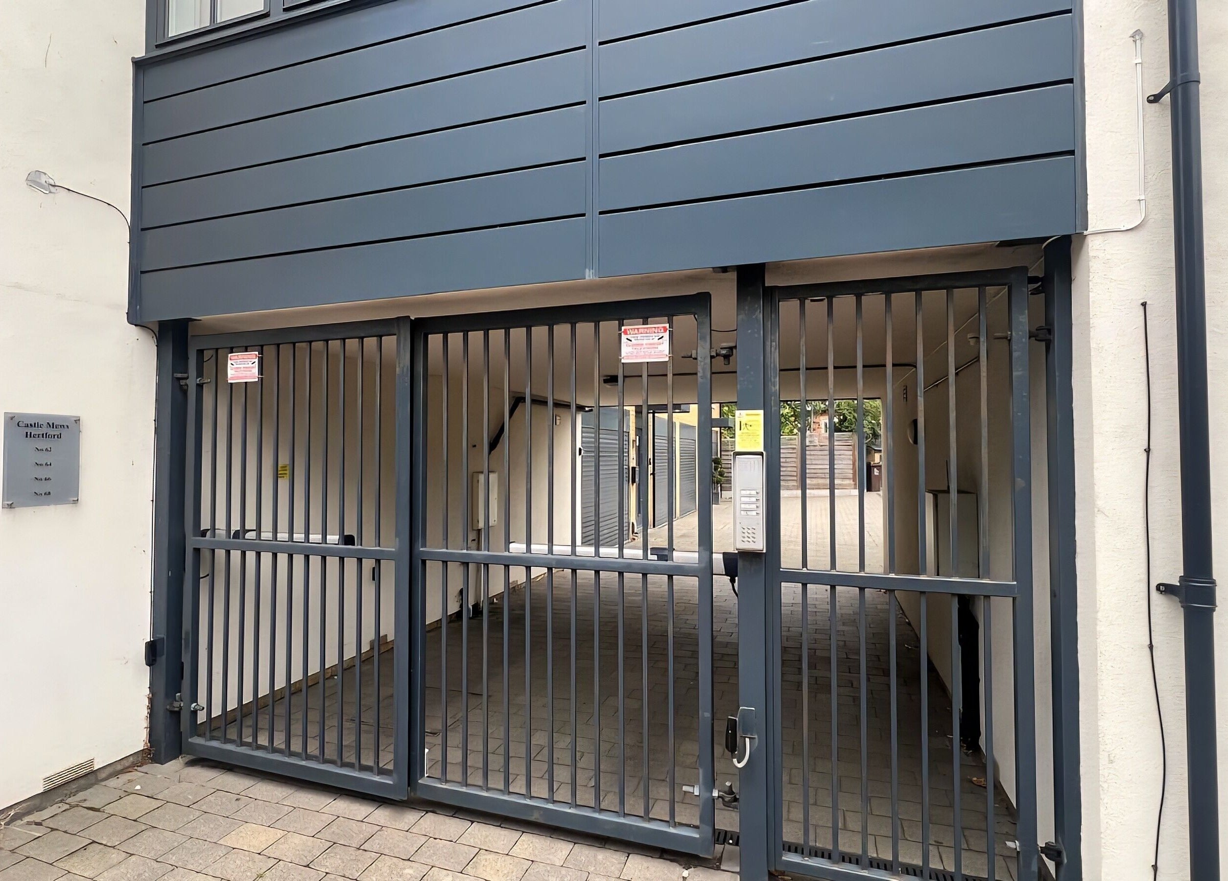 Secure entrance to DERMEDICA Beauty Studio, Hertford, GB, featuring a modern gate and building exterior.