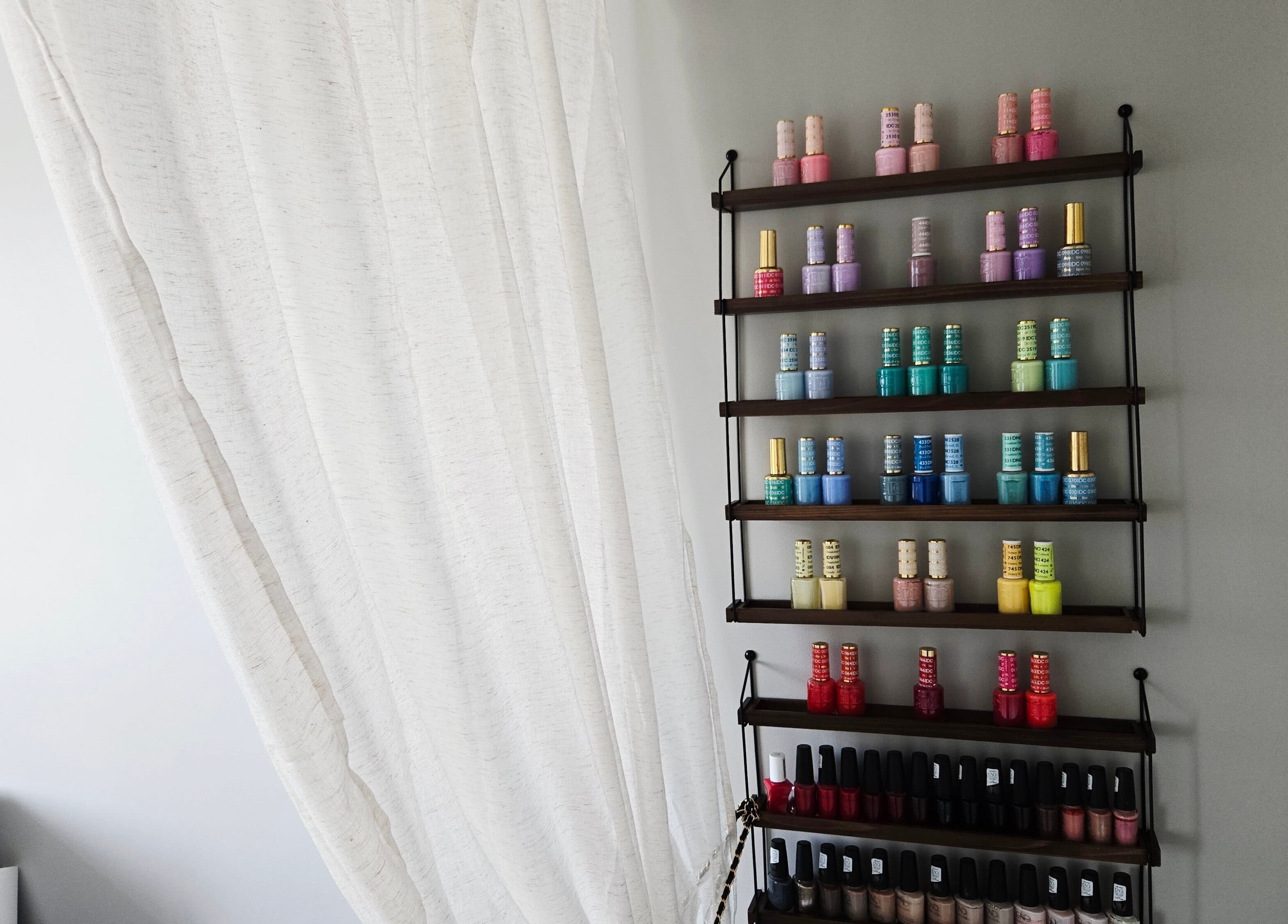 Nail polish rack at DERMEDICA Beauty Studio in Hertford, GB showcasing vibrant colors.
