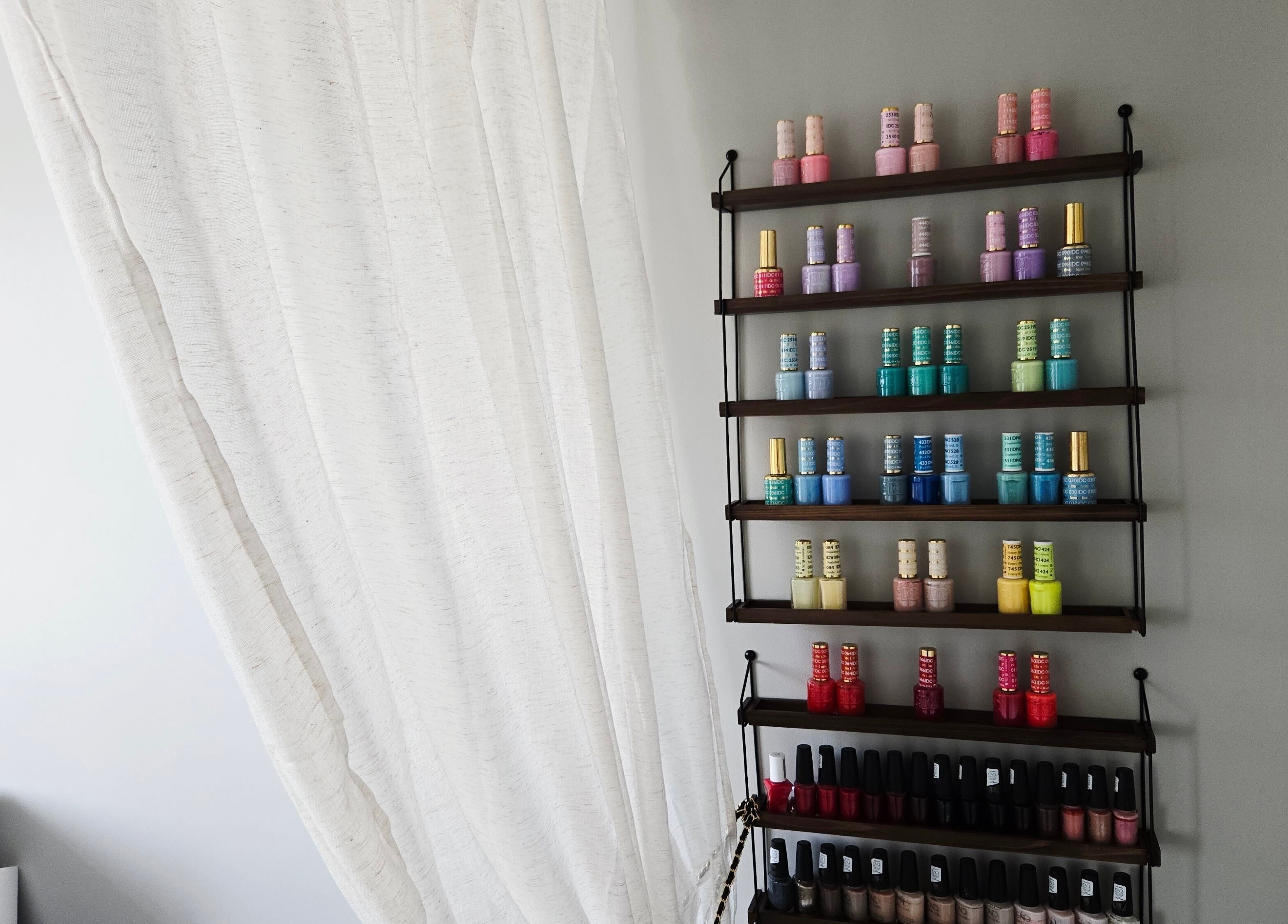 Nail polish rack at DERMEDICA Beauty Studio in Hertford, GB showcasing vibrant colors.