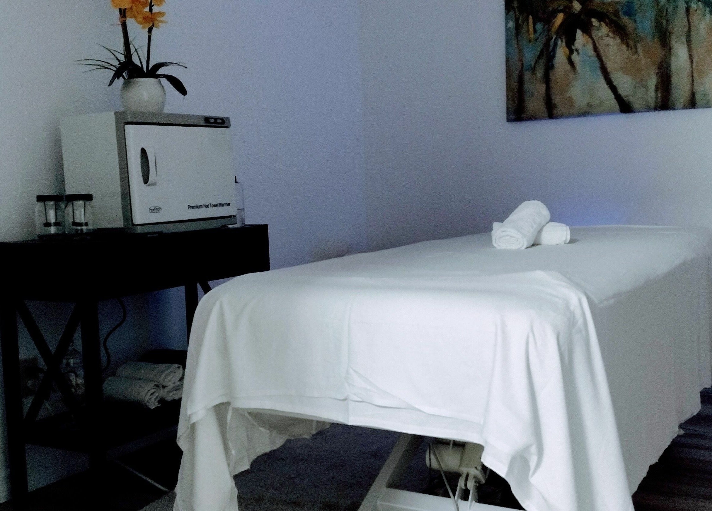 Peaceful massage room at Shape It Body and Face in Fort Myers, Florida, US, with white treatment table.