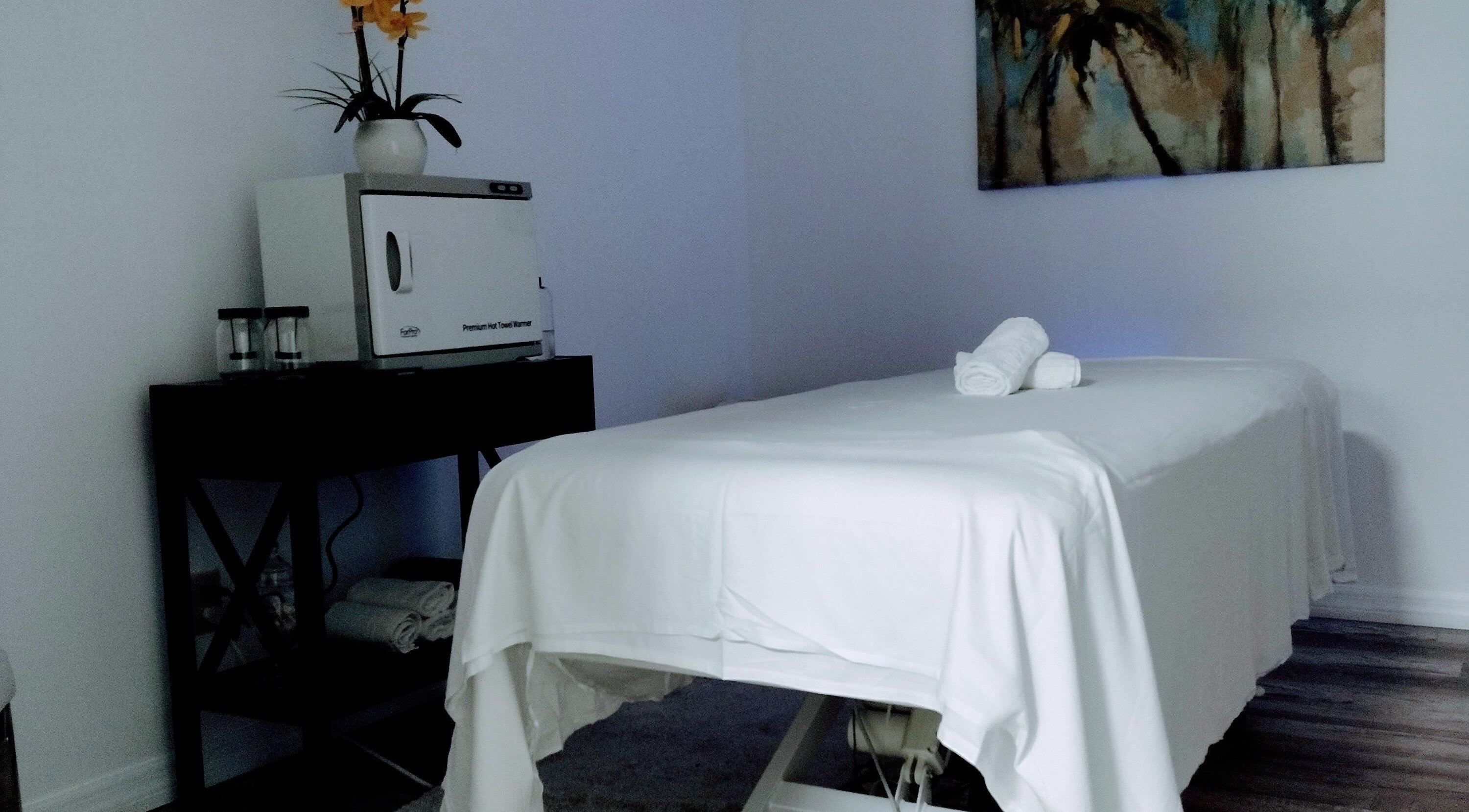 Peaceful massage room at Shape It Body and Face in Fort Myers, Florida, US, with white treatment table.