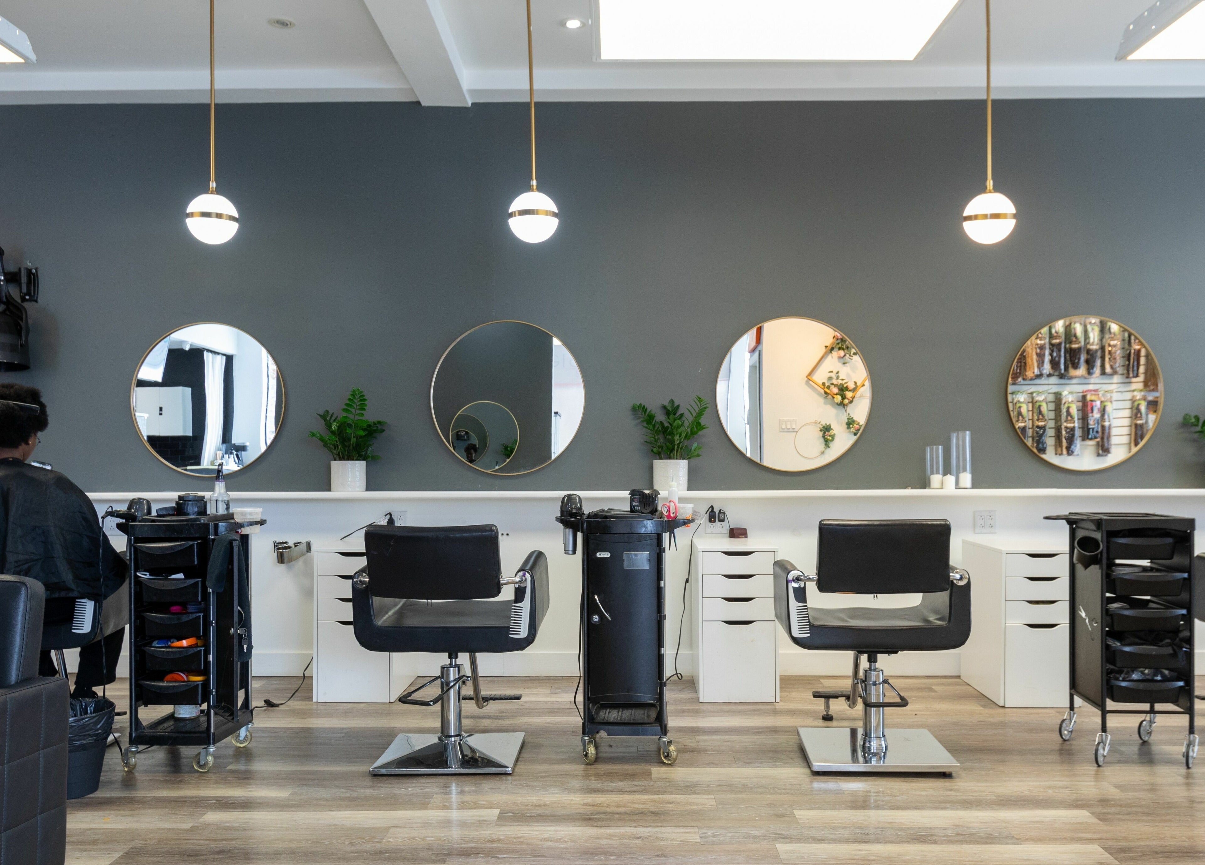 Intérieur chic du Salon Glam Ô Naturel à Montréal, Québec, CA, avec miroirs ronds et chaises stylisées.