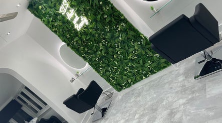 SLS Hair and Beauty in Chessington, England, GB featuring a chic interior with a lush green wall.