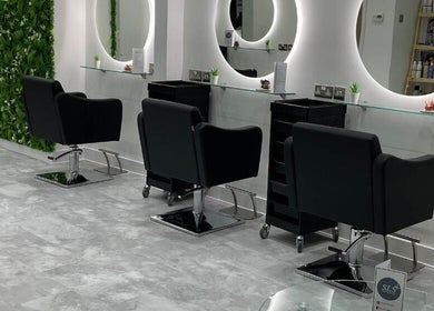 Modern interior of SLS Hair and Beauty in Chessington, England, GB with sleek salon chairs and mirrors.