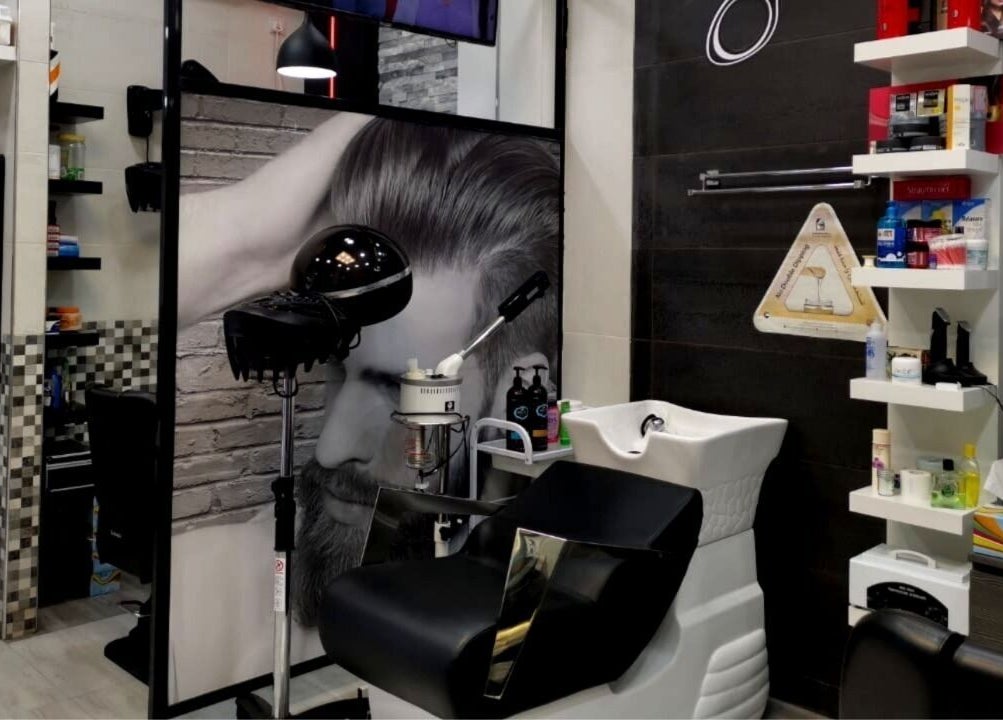 Modern styling station at Kenchie Gents Salon Al Nahda, Dubai, AE, featuring sleek equipment and shelving.
