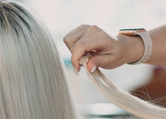 Stylist working on blonde hair at Encanto Salon, Spalding, United Kingdom, GB for a modern look.