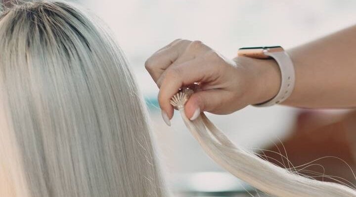 Stylist working on blonde hair at Encanto Salon, Spalding, United Kingdom, GB for a modern look.