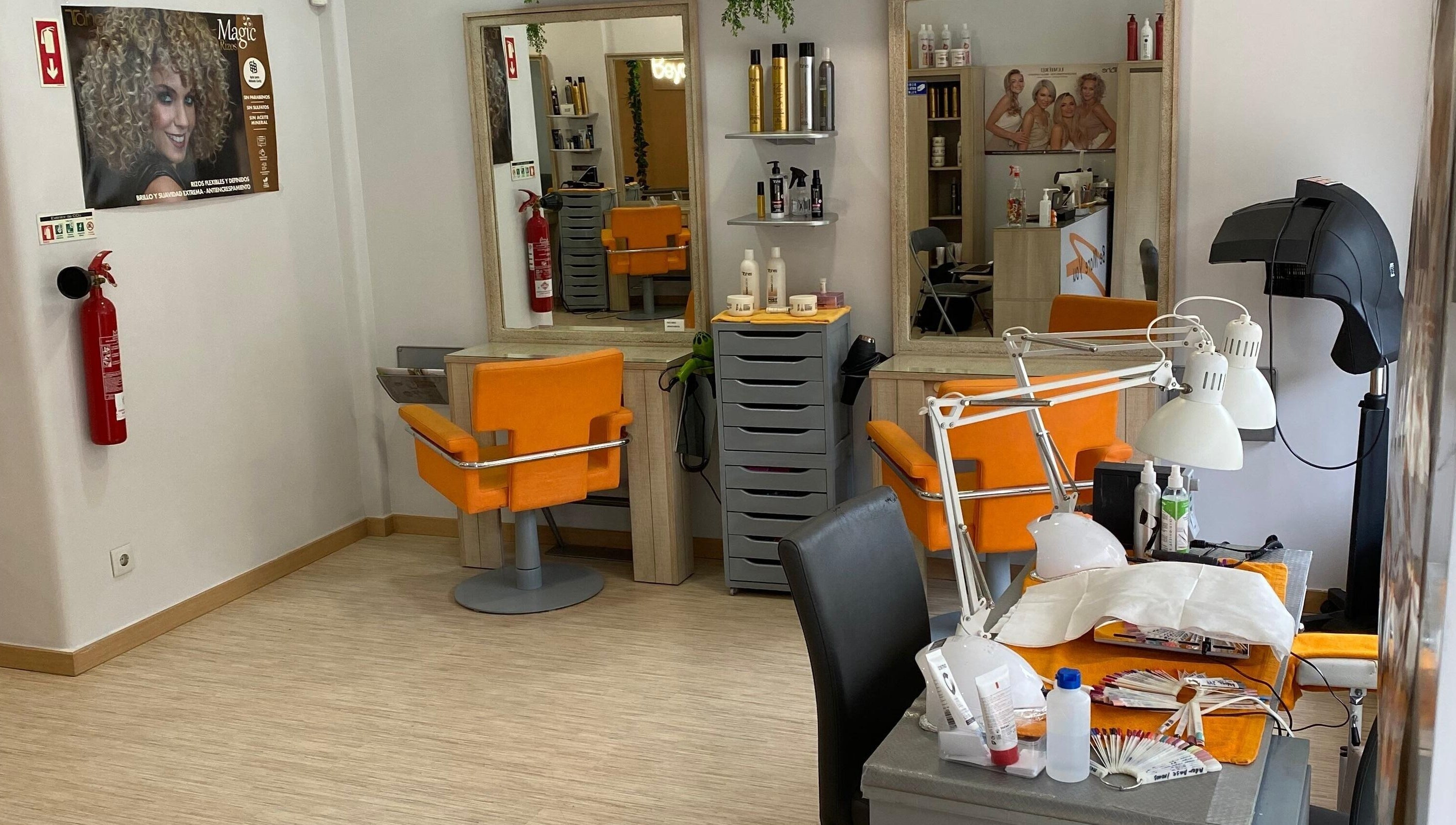 Interior moderno do salão Be More You em Linda-a-Velha, Lisboa, PT, com cadeiras laranja vibrantes.