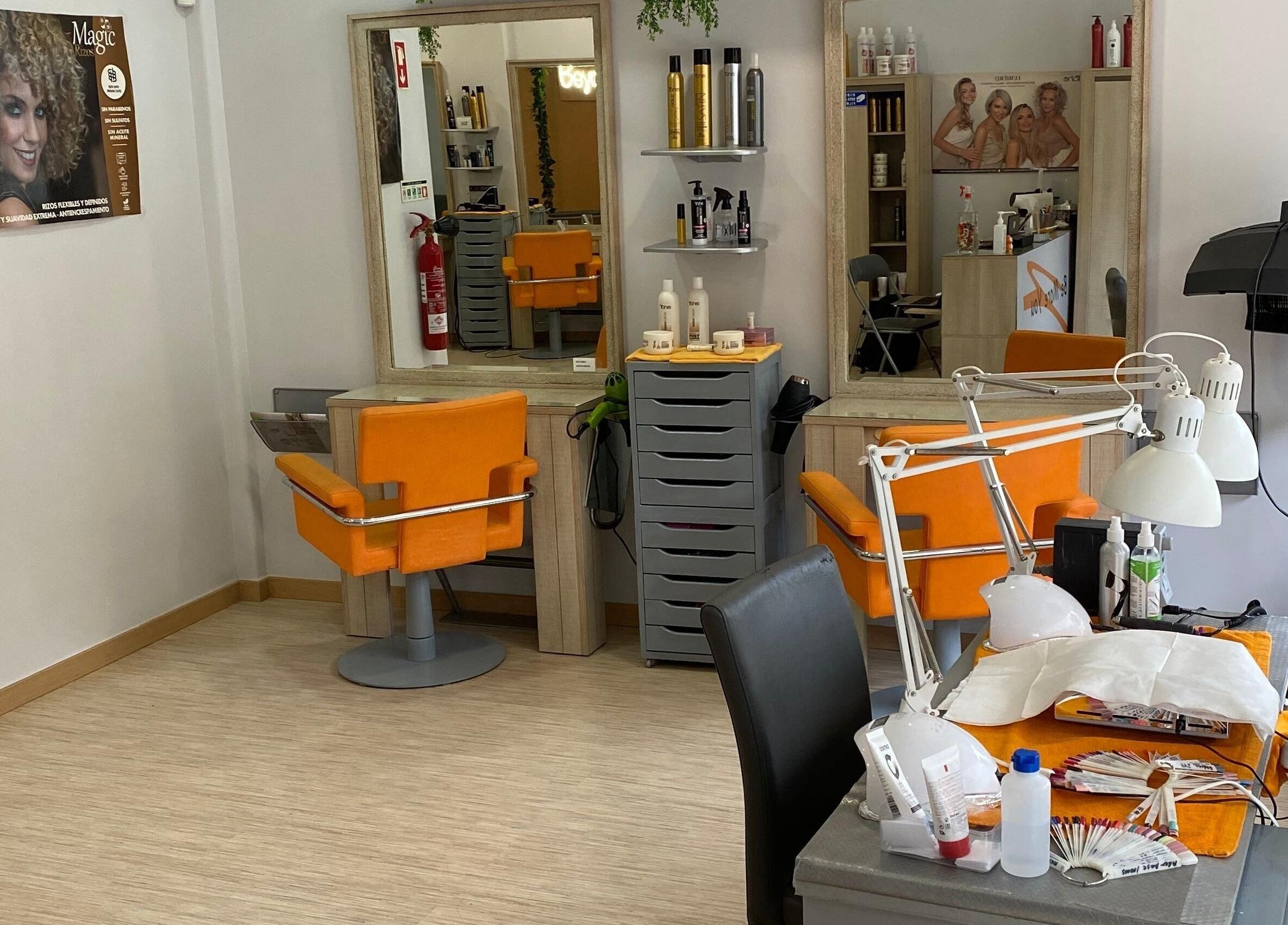 Interior moderno do salão Be More You em Linda-a-Velha, Lisboa, PT, com cadeiras laranja vibrantes.