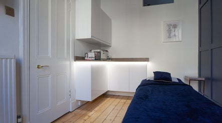 Calming therapy room at Soul Therapy Wellbeing, Edinburgh, Scotland, GB, with a blue massage bed and modern decor.