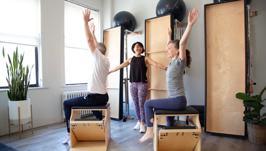 Clients enjoying a Pilates class at Tomoko Pilates NYC, New York, New York, US, with bright natural light.
