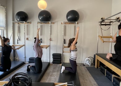 Women practice Pilates on reformers at Tomoko Pilates NYC in New York, New York, US.