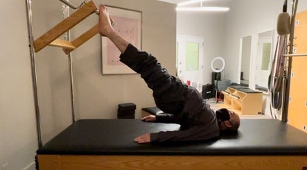 Person practicing Pilates on reformer in Tomoko Pilates NYC studio, New York, New York, US.