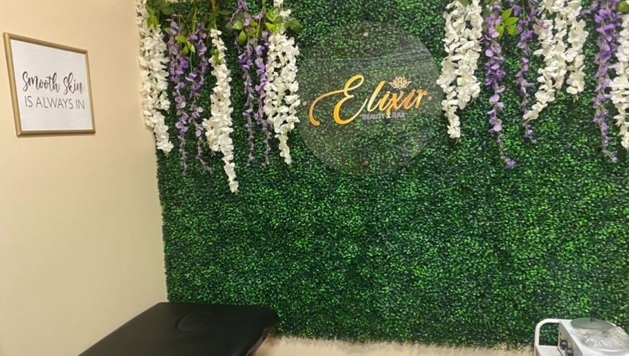 Elixir Beauty Bar's lush floral wall in Freeport, Grand Bahama, BS creating a serene and inviting atmosphere.
