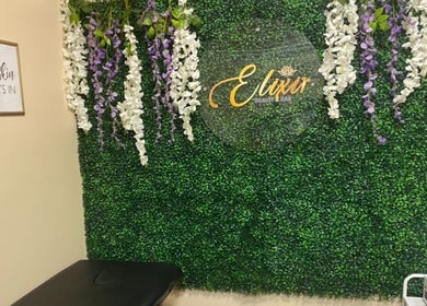 Elixir Beauty Bar's lush floral wall in Freeport, Grand Bahama, BS creating a serene and inviting atmosphere.