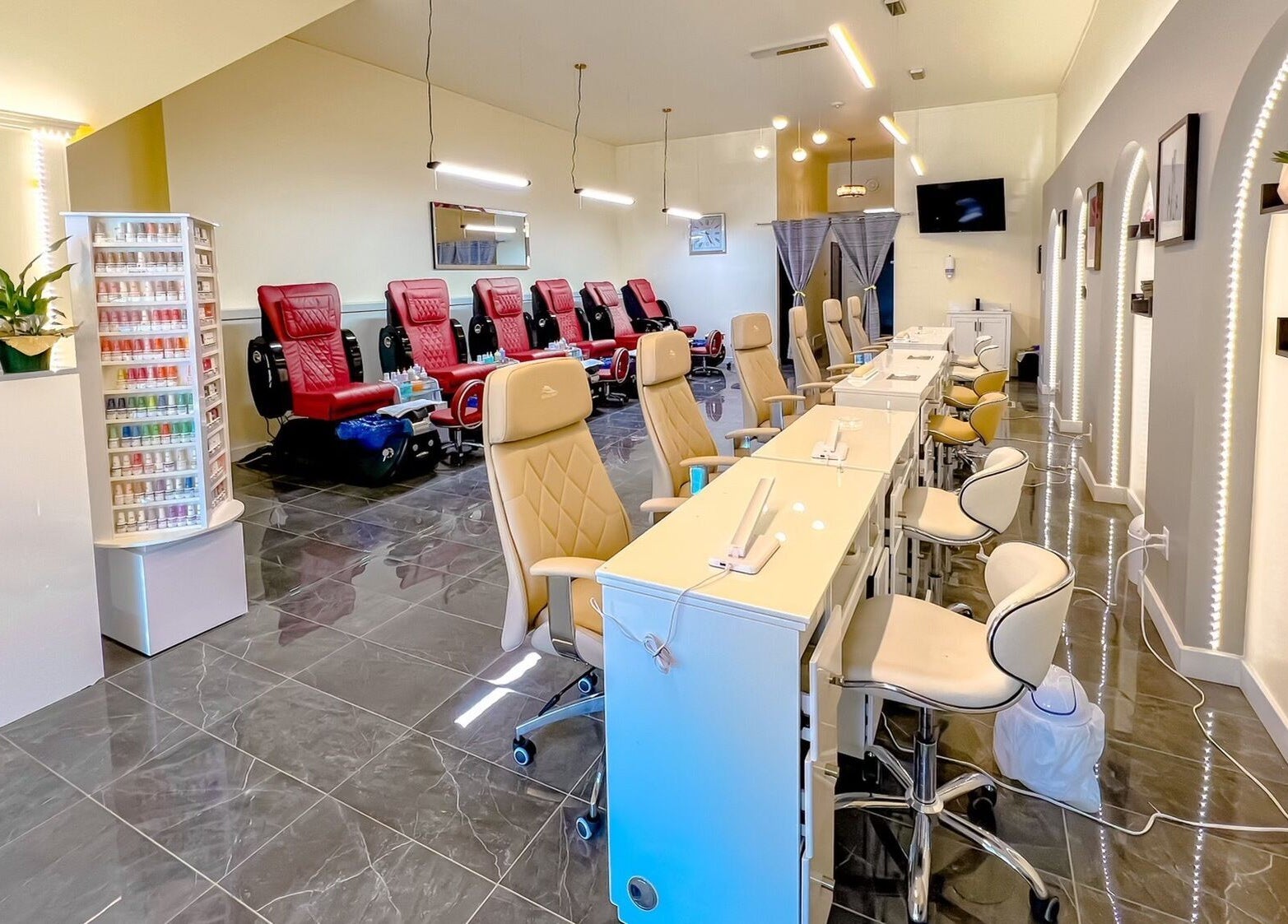 Interior of Solitude Nails Salon in Saskatoon, Saskatchewan, CA, showcasing modern manicure stations and red pedicure chairs.