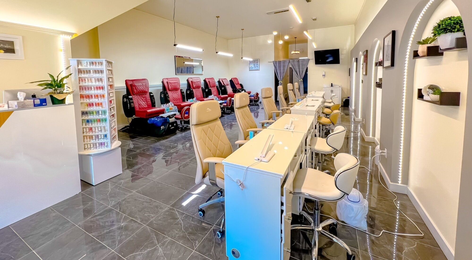 Interior of Solitude Nails Salon in Saskatoon, Saskatchewan, CA, showcasing modern manicure stations and red pedicure chairs.