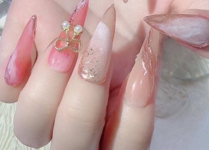 Elegant nail art with pink and gold hues at Solitude Nails Salon, Saskatoon, Saskatchewan, CA.