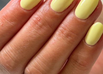 Close-up of vibrant yellow manicured nails at BeautyNailBar, Beograd, RS, showcasing expert nail art.