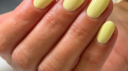 Close-up of vibrant yellow manicured nails at BeautyNailBar, Beograd, RS, showcasing expert nail art.