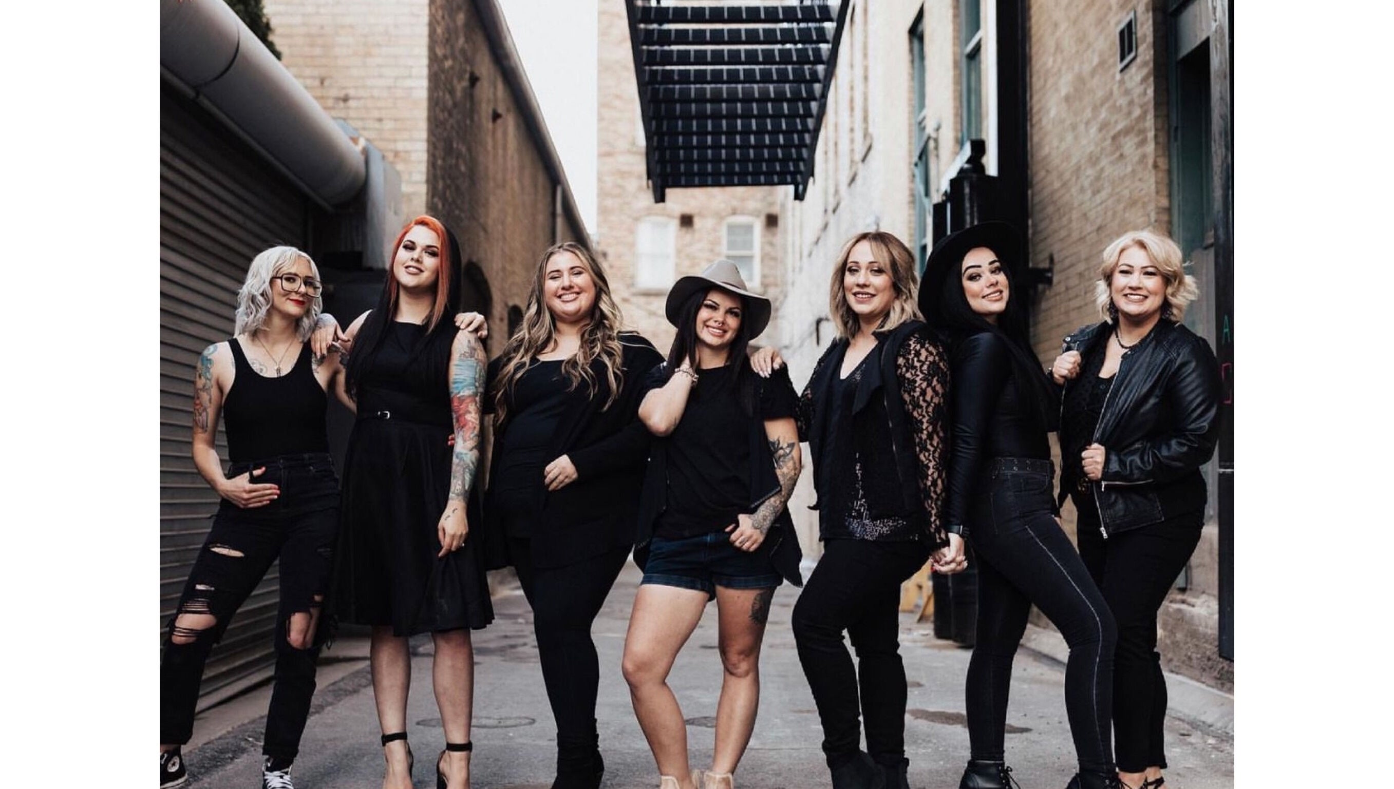 Stylish team at The Beauty Box in Tooele, Utah, US, exudes confidence and camaraderie in a rustic alleyway.