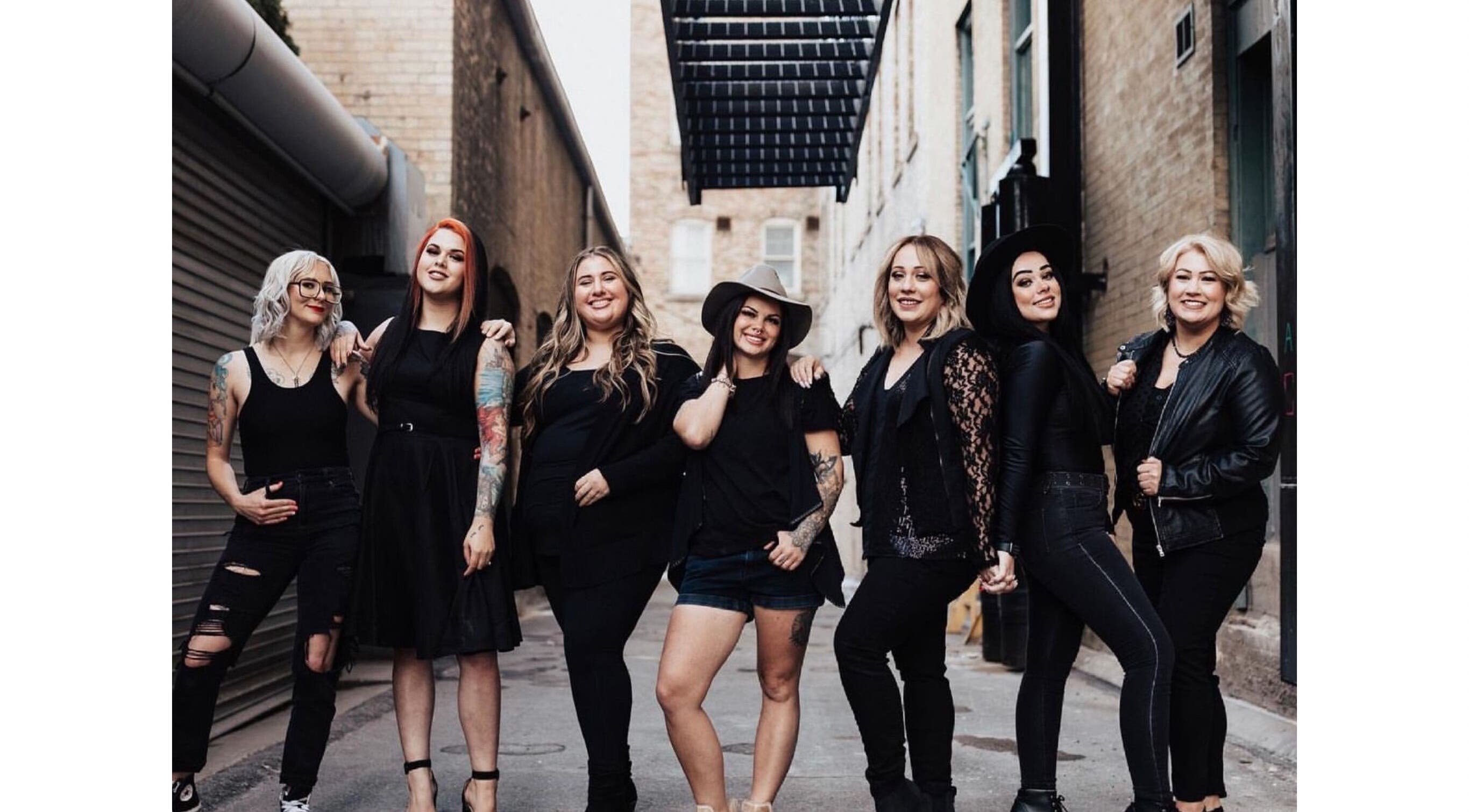 Stylish team at The Beauty Box in Tooele, Utah, US, exudes confidence and camaraderie in a rustic alleyway.