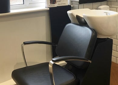 Shampoo station at Salon No.6 Hair And Beauty, Norwich, England, GB, featuring a modern black chair and sink.