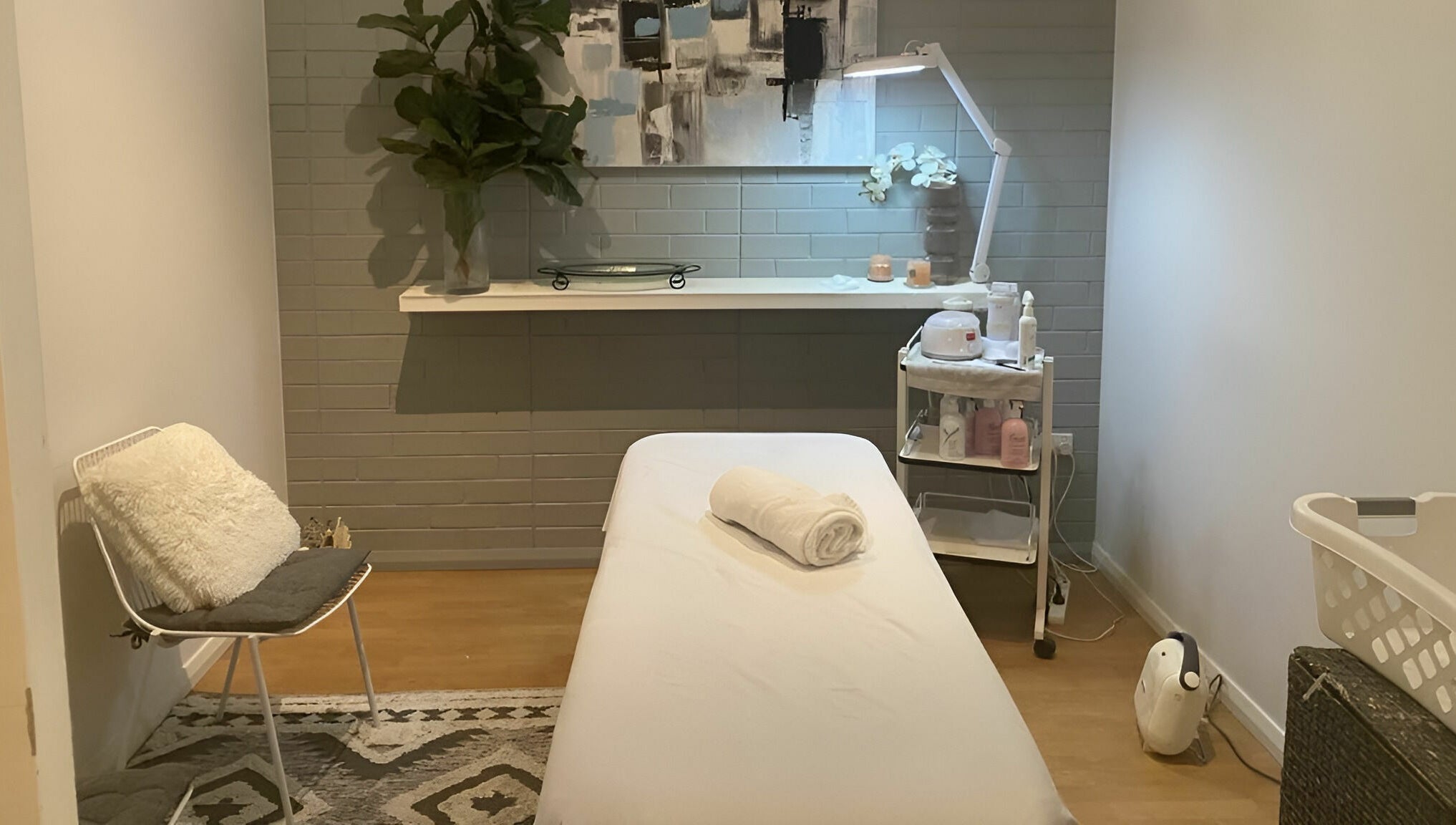 Cozy treatment room at Dynamic Skin Services, Crawley, Western Australia, AU, featuring a massage table and decor.
