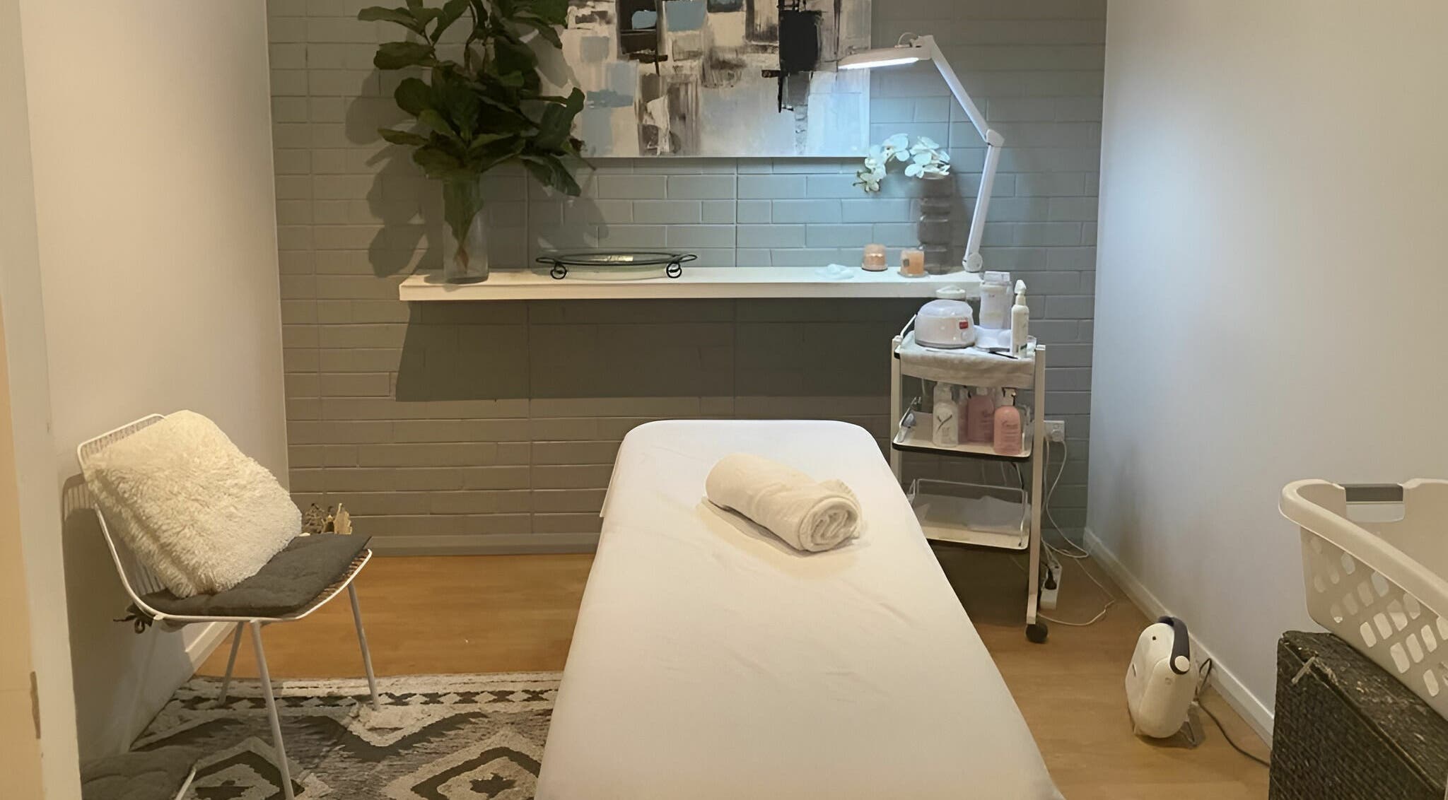 Cozy treatment room at Dynamic Skin Services, Crawley, Western Australia, AU, featuring a massage table and decor.