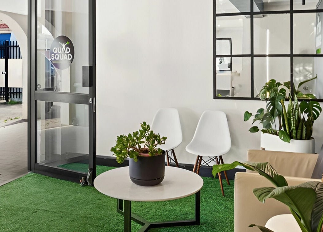 Welcoming entrance of Quad Squad Massage Co in Rosebery, New South Wales, AU with modern seating and lush plants.
