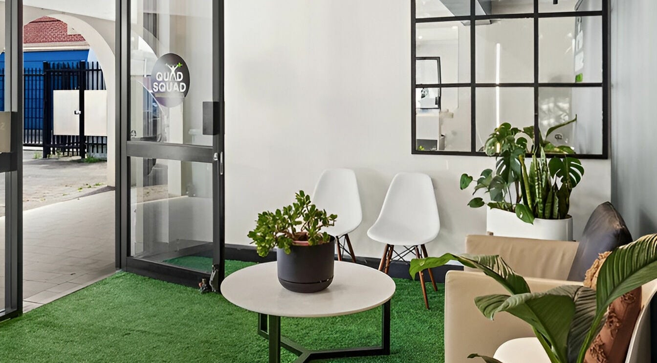 Welcoming entrance of Quad Squad Massage Co in Rosebery, New South Wales, AU with modern seating and lush plants.