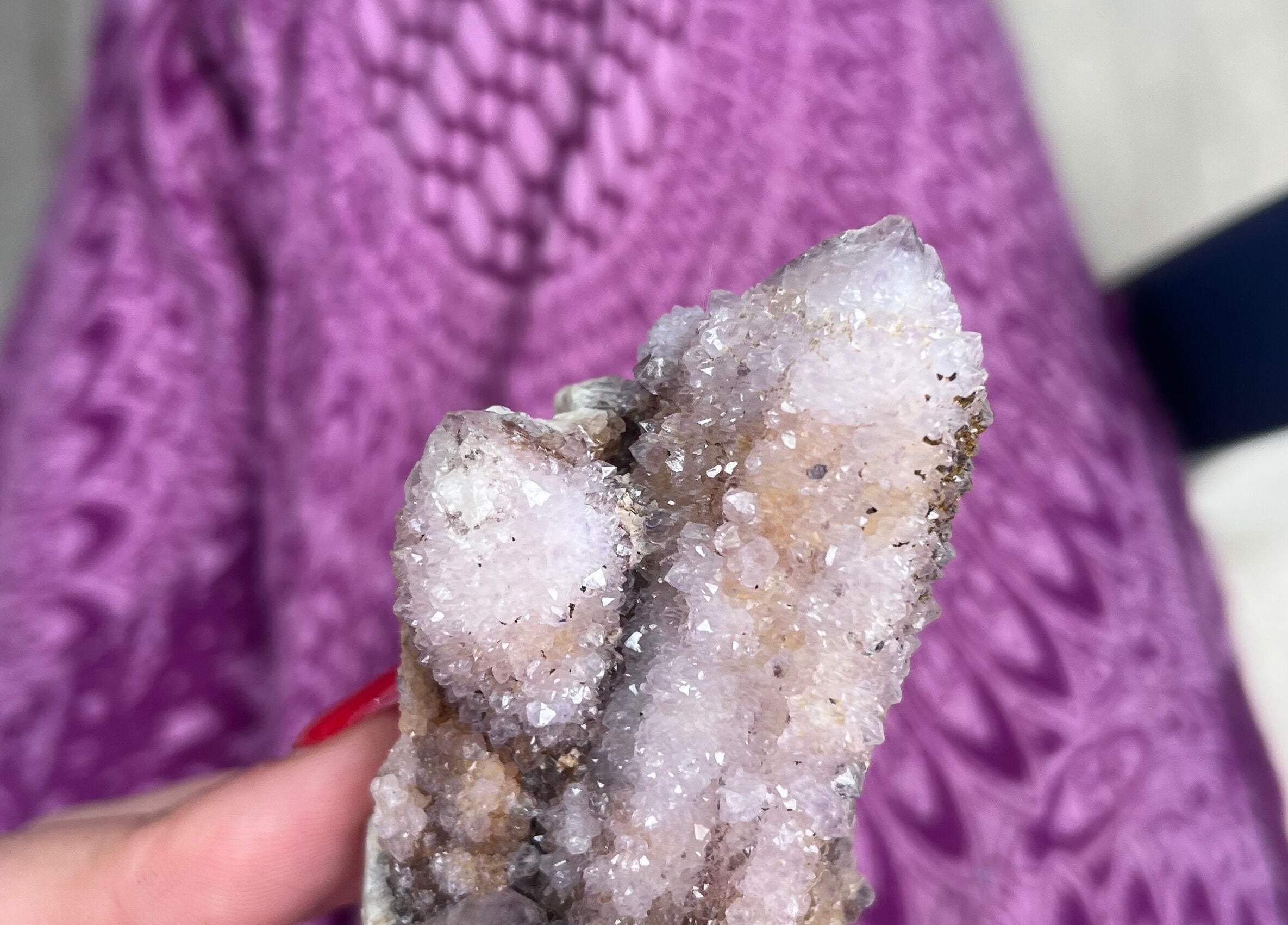 Hand holding sparkling crystal at Shadow Sanctuary Healing, Randburg, Gauteng, ZA. Purple-patterned background.